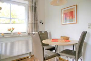 a dining room with a table and chairs and a window at Rugstieg 8 Whg 2 in Wyk auf Föhr