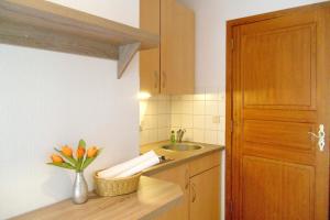 a kitchen with a sink and a vase of flowers on a counter at Rugstieg 8 Whg 2 in Wyk auf Föhr