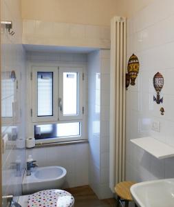 a white bathroom with a sink and a window at B&B Il Campanile in Barletta