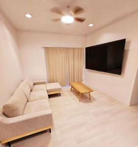 a living room with a couch and a flat screen tv at Itoshima STAY YAMAGA Keya in Itoshima