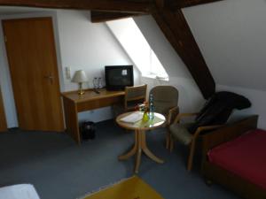 a room with a desk and a tv and a table at Gasthof Adler in Salem