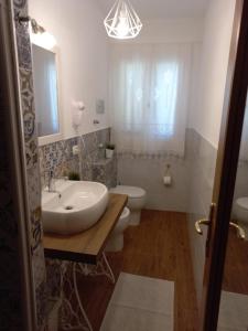 a white bathroom with a sink and a toilet at Sunrise in Lascari +27 photos