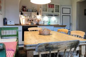 a kitchen with a wooden table with chairs and a sink at Midlum- Finnegan, EG in Midlum