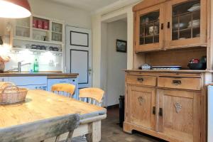 a kitchen with wooden cabinets and a wooden table at Midlum- Finnegan, EG in Midlum