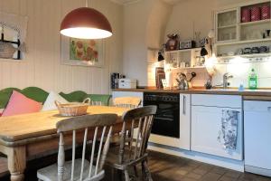 a kitchen with a wooden table and a dining room at Midlum- Finnegan, EG in Midlum +12 photos
