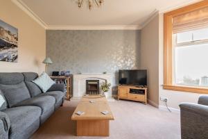 a living room with a couch and a fireplace at Avoncliffe in Crail