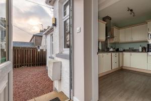a kitchen with white cabinets and a window at Avoncliffe in Crail