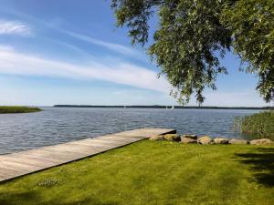 a walkway next to a body of water at Ferienhaus Peeneblick - exklusives Traumhaus in Direktlage am Wasser mit Bootssteg und Aussensauna in Rankwitz