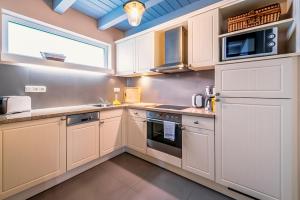 a kitchen with white cabinets and a microwave at Bauernkate Seerose in Liepe