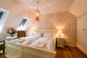 a bedroom with a white bed with floral wallpaper at Bauernkate Seerose in Liepe +5 photos