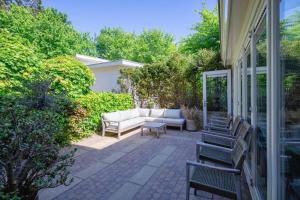 a patio with a couch and chairs on a house at Hotel Zeerust in De Koog