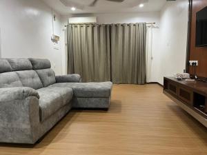 a living room with a couch and a television at LIY Homestay in Gua Sai