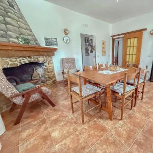 a dining room with a table and a fireplace at Da Nonno Francesco in Teulada +13 photos