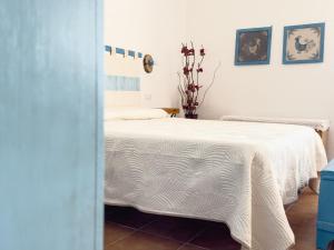 a bedroom with a bed with a white blanket at Da Nonno Francesco in Teulada