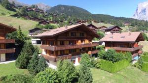 una casa grande en un valle con montañas en Apartment Eiger - GRIWA RENT AG, en Grindelwald