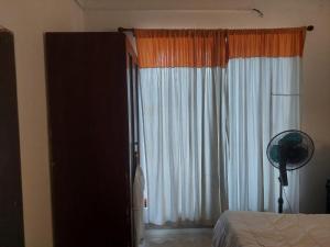 a bedroom with a bed and a window with a fan at Sun Power Villa in Hokandara South