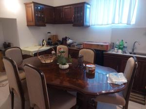 a kitchen with a wooden table and chairs and a table and a counter at Sun Power Villa in Hokandara South