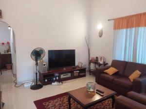 a living room with a couch and a flat screen tv at Sun Power Villa in Hokandara South