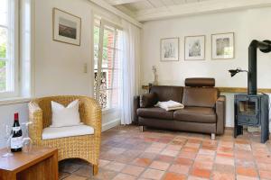 a living room with a couch and a chair and a stove at Süderende- Hus Lillesol in Süderende