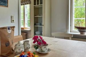 a kitchen with a table with a vase of flowers on it at Süderende- Hus Lillesol in Süderende