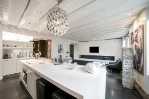 a kitchen with a large white counter and a chandelier at Fontaine in Geneva