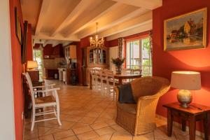 a kitchen and dining room with red walls and chairs at Ferienhaus Kranich in Krienke