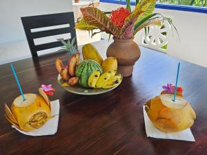a table with two drinks and a bowl of fruit at Nelum Vegan House in Bentota