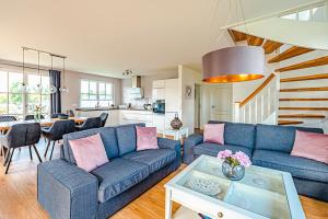 a living room with a blue couch and a table at Kramerhof Rügenblick Nr 53 in Parow