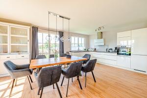 a kitchen with a wooden table and chairs at Kramerhof Rügenblick Nr 53 in Parow +15 photos