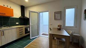 a kitchen with a table and a dining room at S'apartments New in Leiria
