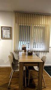 a dining room table and chairs with a table and blinds at S'apartments New in Leiria