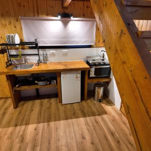 a kitchen with a counter with a sink and a stove at Premium Cabin in El Bolsón in El Bolsón