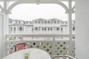 a white balcony with a table and a building at Fewo 517, Seepark Sellin in Ostseebad Sellin