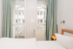 a bedroom with a bed and a window with green curtains at Fewo 517, Seepark Sellin in Ostseebad Sellin