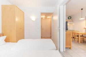 a bedroom with two beds and a kitchen with a table at Fewo 517, Seepark Sellin in Ostseebad Sellin +7 photos