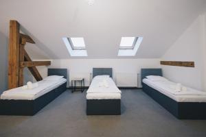 two beds in a room with skylights at Folwark Matecznik - Dworek in Sęzinko +9 photos