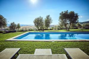 a swimming pool in the middle of a grass field at Podere Lamone a Monticchiello in Monticchiello