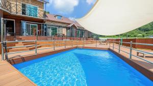 a swimming pool on a deck with a canopy over it at Gapyeong Haneulsup Spa Pension in Gapyeong