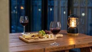 two glasses of wine and cheese on a wooden table at Gapyeong Namian Pool Villa in Gapyeong +1 photo