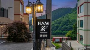 a street light with a sign on it next to a building at Gapyeong Namian Pool Villa in Gapyeong