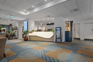 a lobby with a counter in the middle of a building at Home Hotel Astoria in Hamar