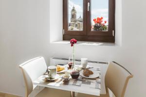 un tavolo con un piatto di cibo e un fiore sopra di Foresteria dell'Abbazia a Montescaglioso