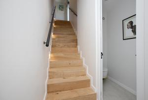 a staircase in a home with white walls and wooden floors at Table Mountain Constantiaberg view in Sweet Valley