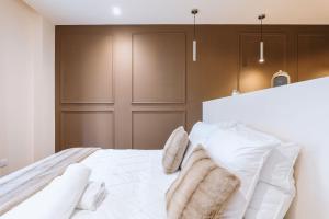 a bedroom with a white bed with white pillows at Suite Cognac - International Palace - Jacuzzi in Vichy