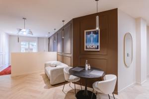 a living room with a table and a chair at Suite Cognac - International Palace - Jacuzzi in Vichy