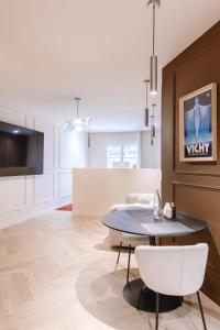 a kitchen and living room with a table and chairs at Suite Cognac - International Palace - Jacuzzi in Vichy