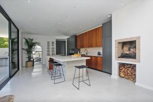 a kitchen with a counter and stools and a fireplace at Table Mountain Constantiaberg view in Sweet Valley