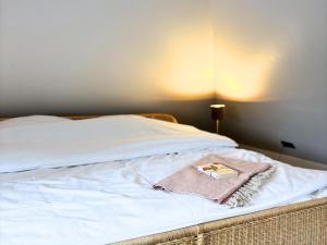a bed with a towel and a book on it at Frederick Brückenblick in Wulfen auf Fehmarn