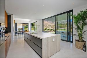 a kitchen with a large island in a house at Table Mountain Constantiaberg view in Sweet Valley +73 photos