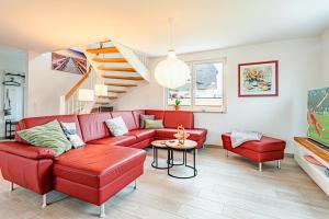 a living room with a red couch and a table at Kramerhof Ferienhaus Luv und Lee in Parow
